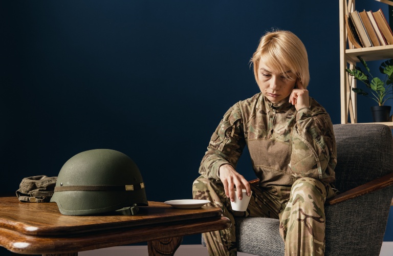 female veteran sitting looking down at the floor