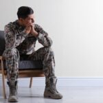 Military man in fatigues sitting in a waiting room_s