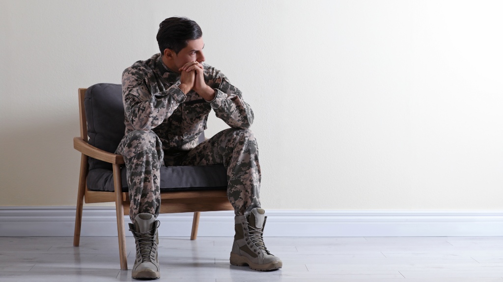 Military man in fatigues sitting in a waiting room